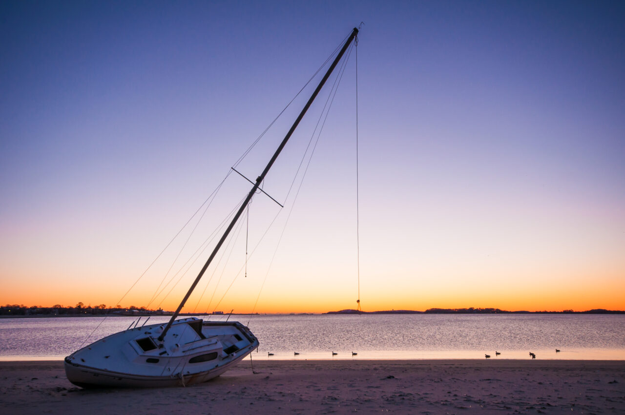A boat beached during sunrise.