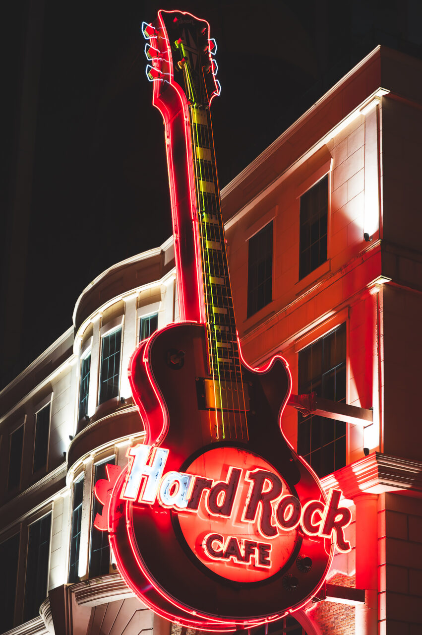 The Hard Rock Cafe Guitar Sign lit up at night.