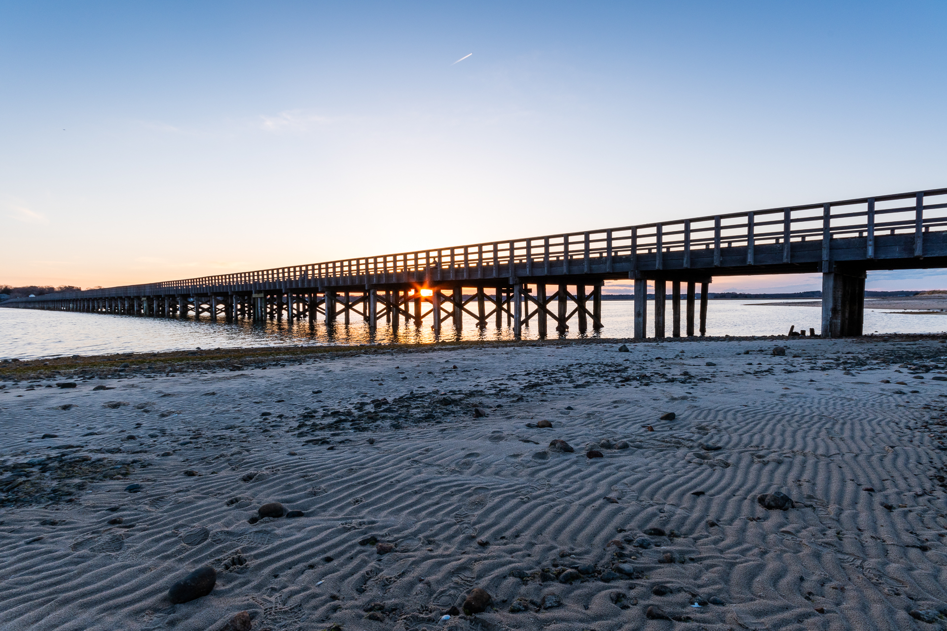 A wide angle view of the sun setting over Powder Point Bridge