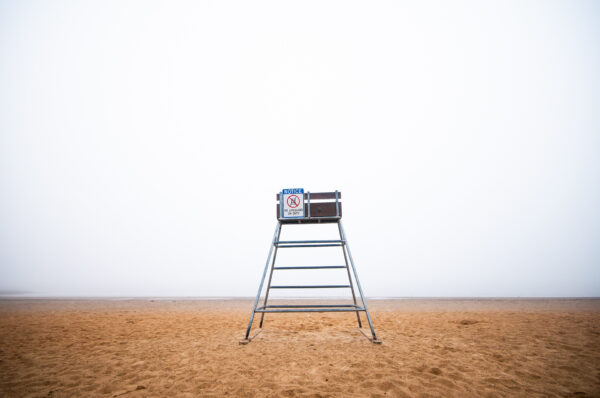 An empty lifeguard chair sits at the Houghton's Pond Recreation Area within the Blue Hills Reservation on a foggy day.