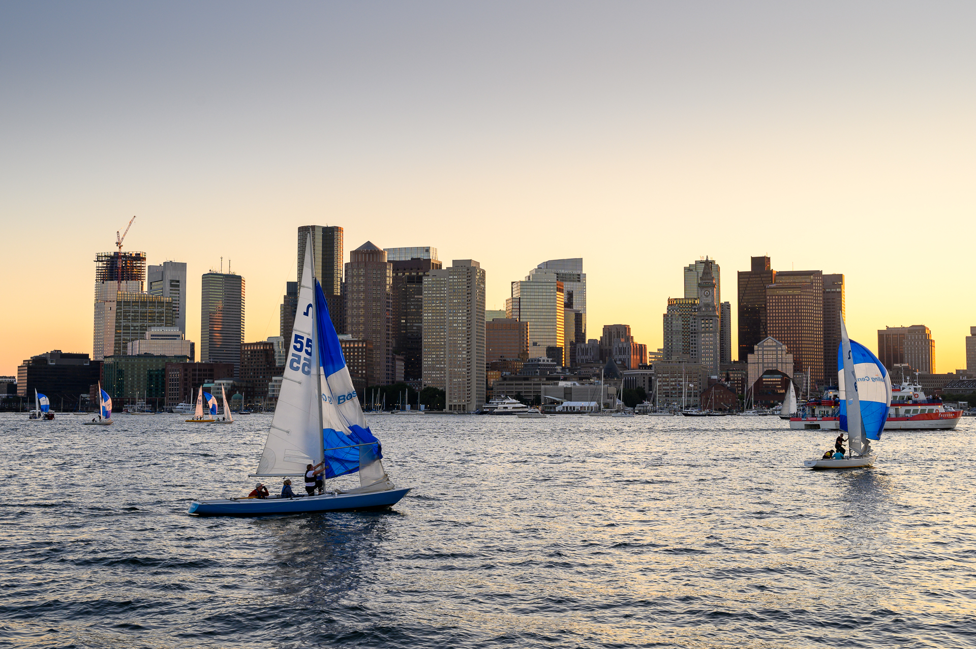 Sailboats making their way back to shore as the sun started to set at Boston Harbor.