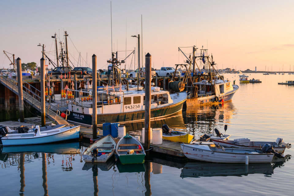 Boats docked at Scituate Harbor, Massachusetts, bask in the warm hues of the morning light.