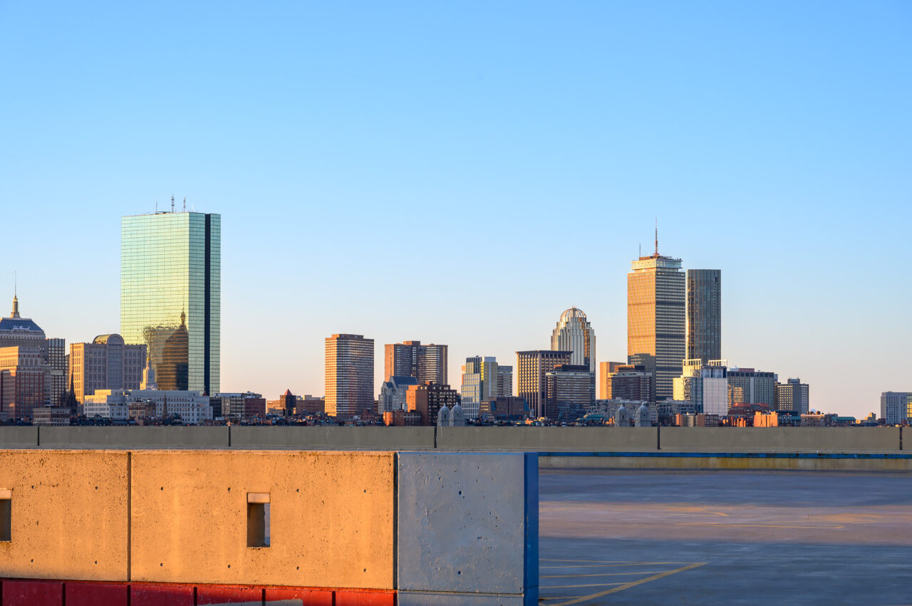 A hidden vantage point overlooking the Boston skyline at sunrise, with a parking garage in the foreground.