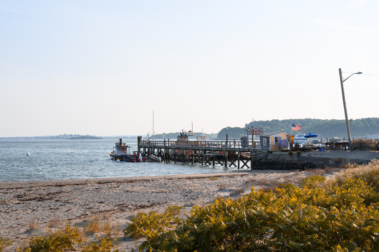 Scenic view of the wooden fishing pier extending into the water at Pemberton Point, Hull, Massachusetts.