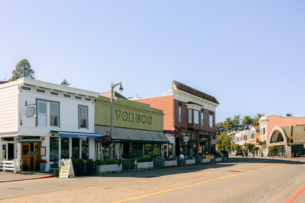 The Venice restaurant and other storefronts along a street in Sausalito.