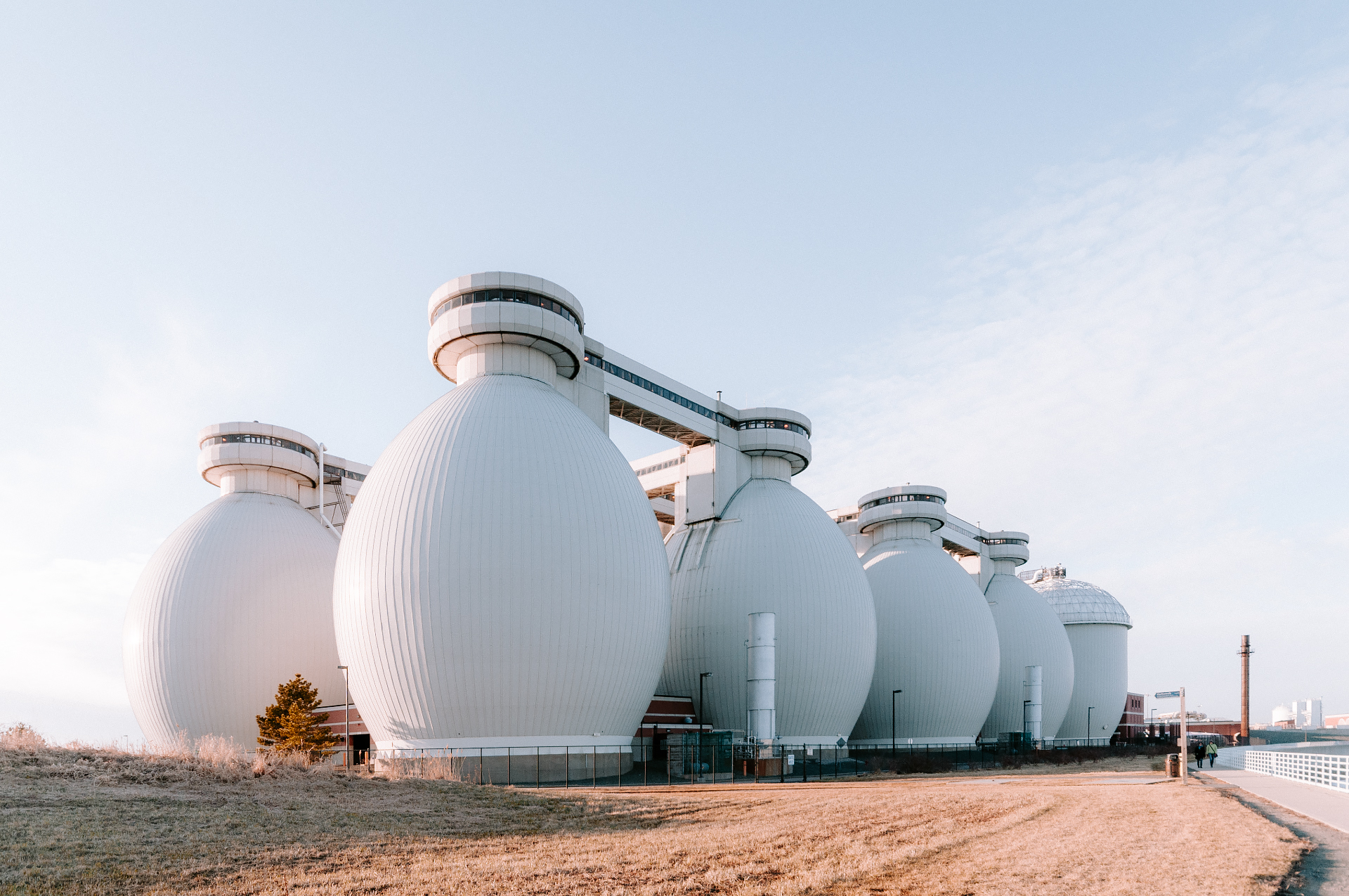 Deer Island digesters seen across the harbor in soft afternoon light.