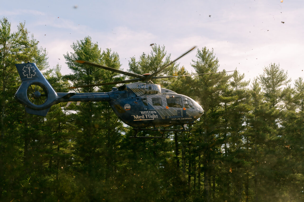 A Boston MedFlight helicopter lands at Myles Standish State Forest, kicking up a large cloud of dust during a medical emergency.