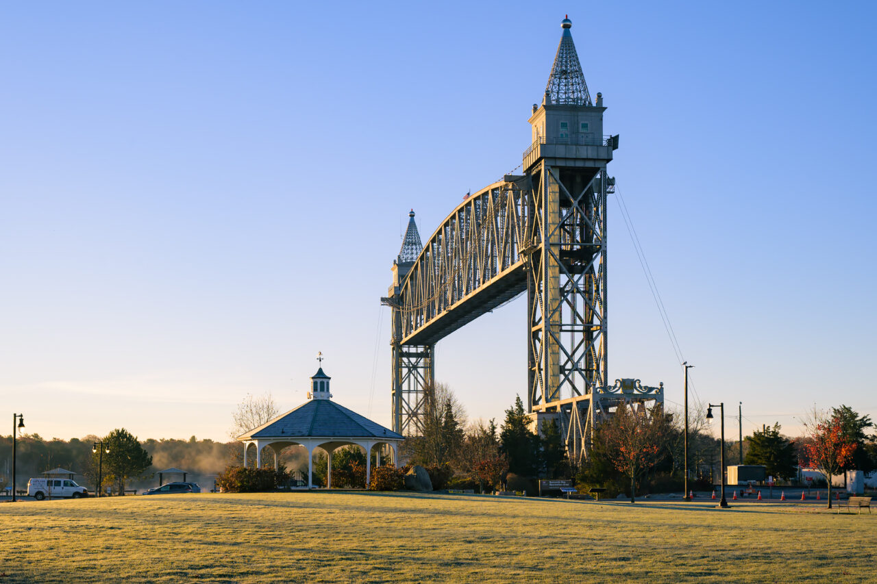 The majestic Cape Cod Canal Railroad Bridge is viewed from a grassy park at the Buzzards Bay Recreation Area shortly after sunrise.