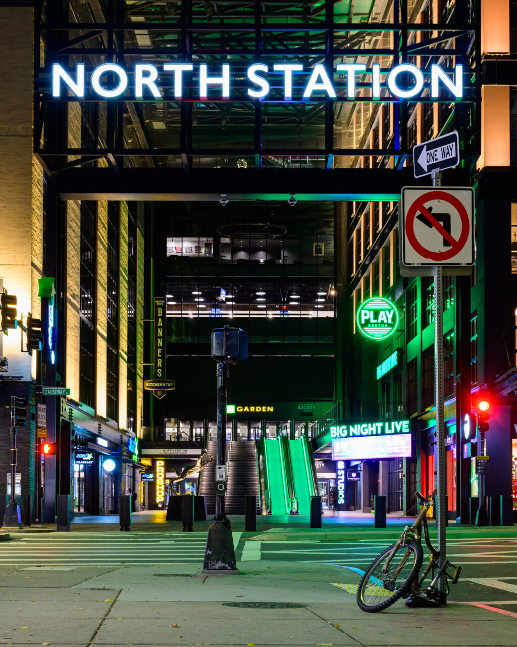 North Station entrance sign glowing above Causeway Street in Boston at night.
