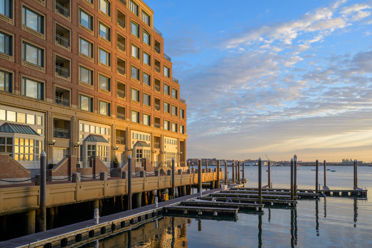 Empty wooden docks at the Boston Harborwalk glowing in the early morning solstice light.