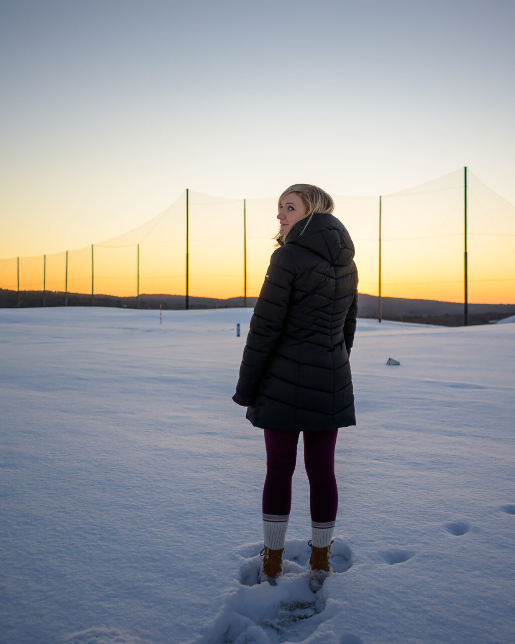 My beautiful wife watching the sunset glow over the snow-blanketed hills of the Granite Links practice grounds.