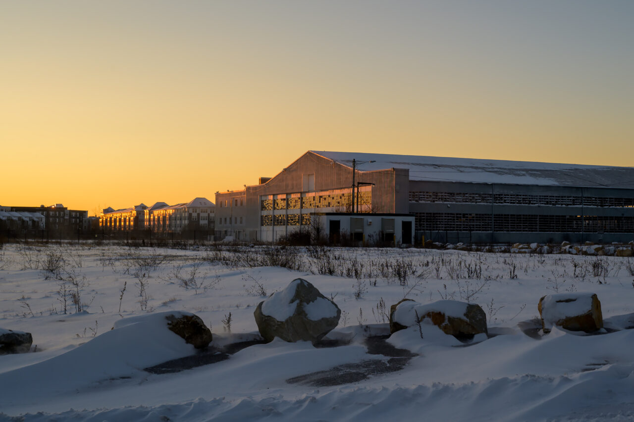 An old hangar at the former South Weymouth Naval Air Station as golden hour light fades into sunset.