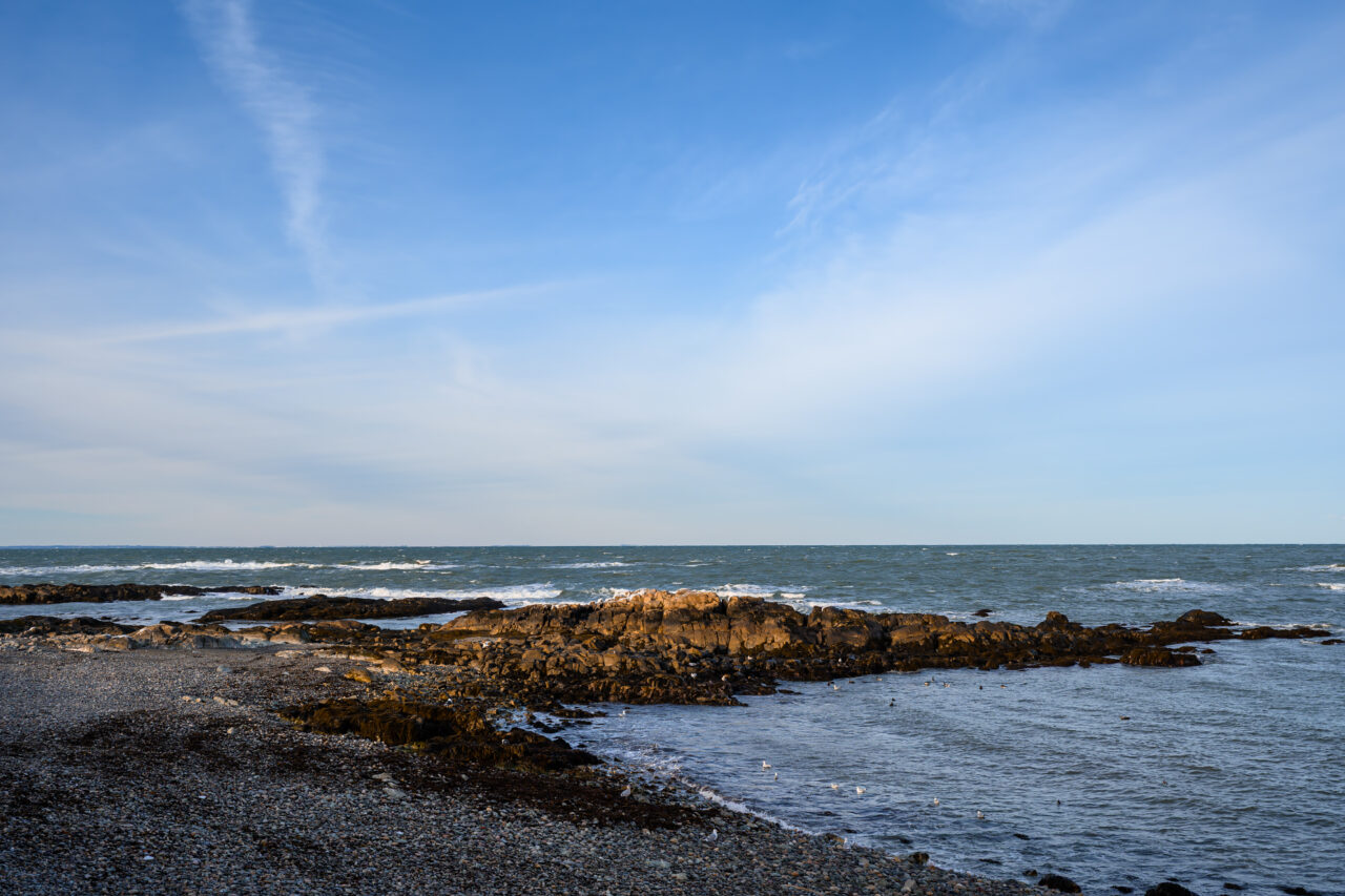 Chilly Atlantic waves crash against a dark, rocky outcrop along Jerusalem Road in Cohasset.