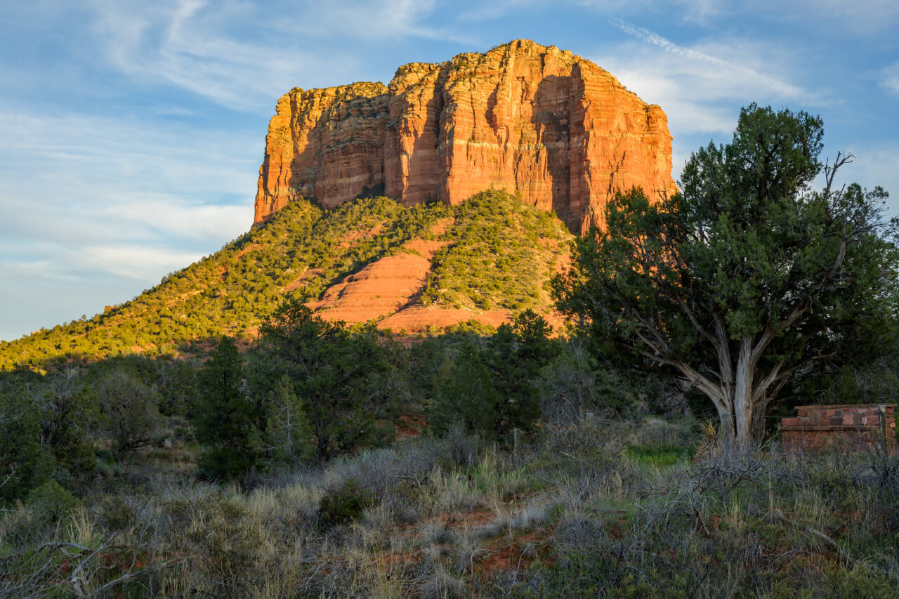 Sunlight hitting the side of Courthouse Butte, viewed from the Bell Rock Trailhead, highlighting its dramatic red textures.