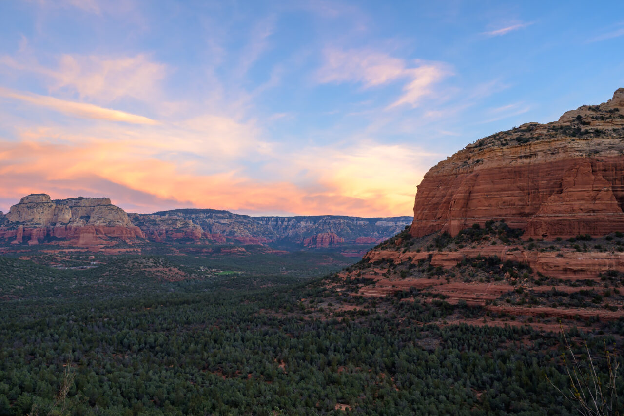 Cotton candy sunrise sky over Sedona red rock landscape from Devil's Bridge trail.
