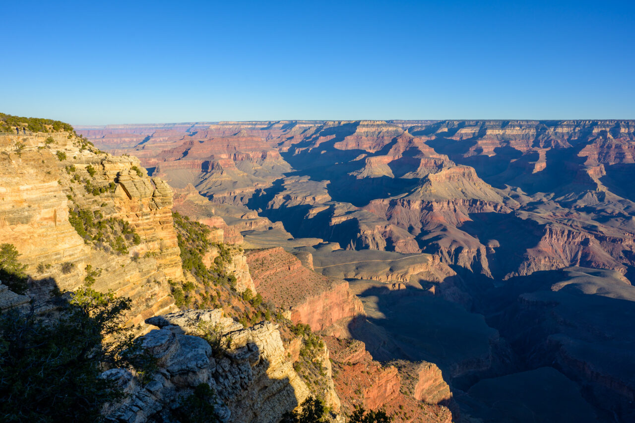 Grand Canyon South Rim view with foreground rock and layered canyon walls.
