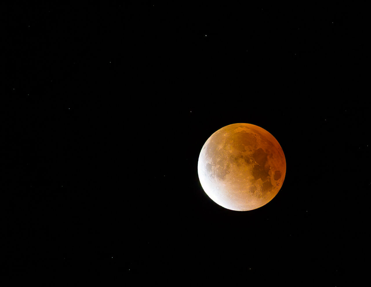 A detailed view of the copper-colored moon during a lunar eclipse in the dark Sedona sky.