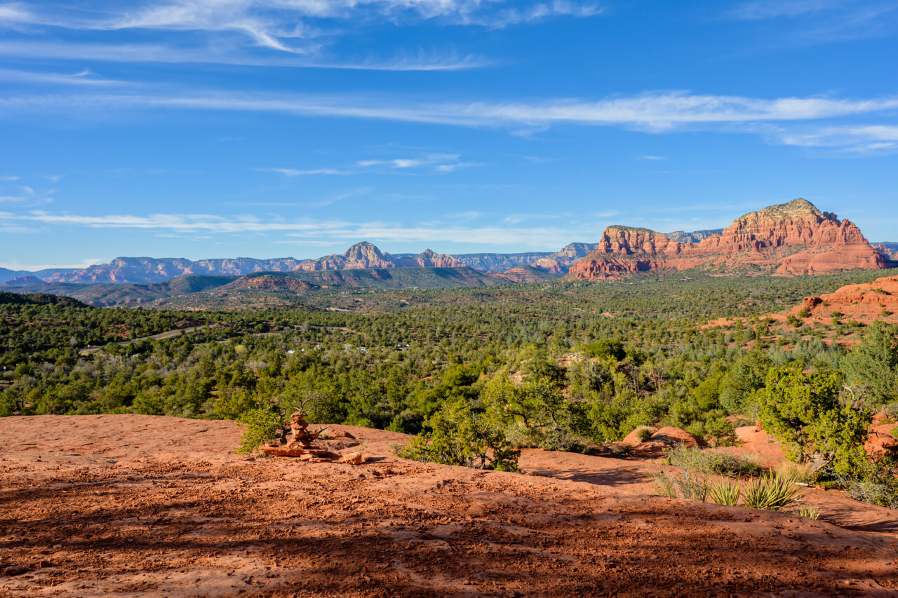A wide, breathtaking vista overlooking the green desert valley and red rock formations in Sedona.