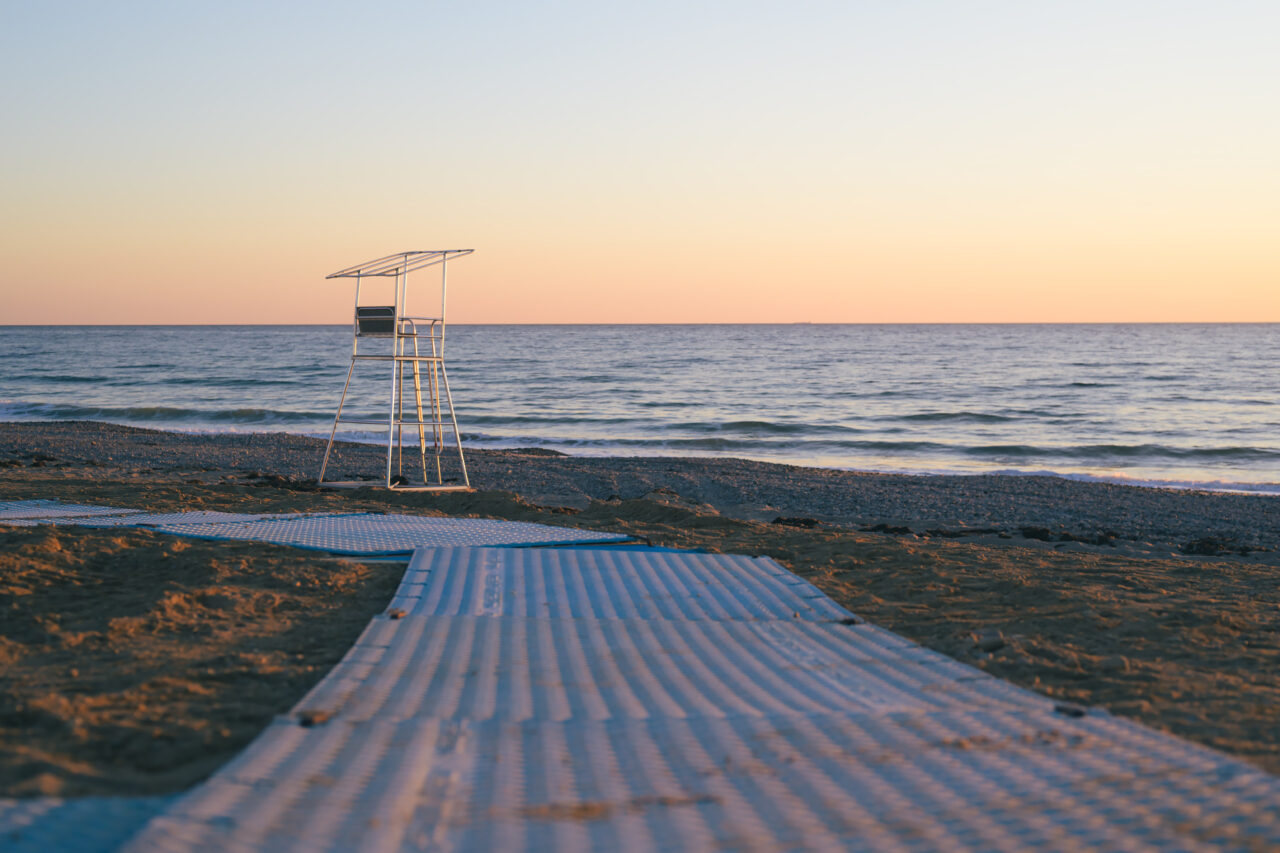 Empty lifeguard stand at Duxbury Beach with accessible beach mat at sunrise.