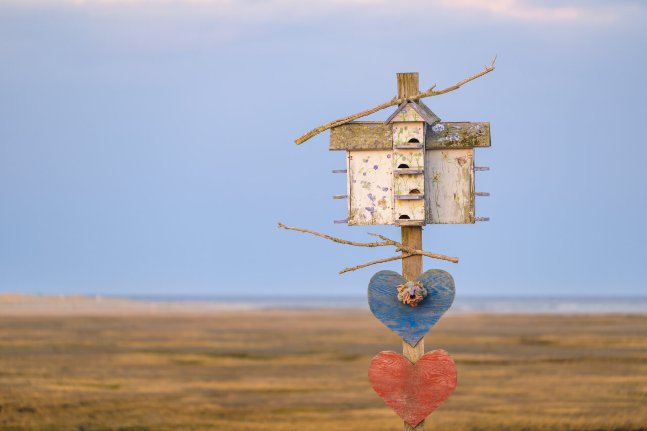 Weathered birdhouse with painted hearts on a post overlooking the marsh at Damon's Point in Marshfield.