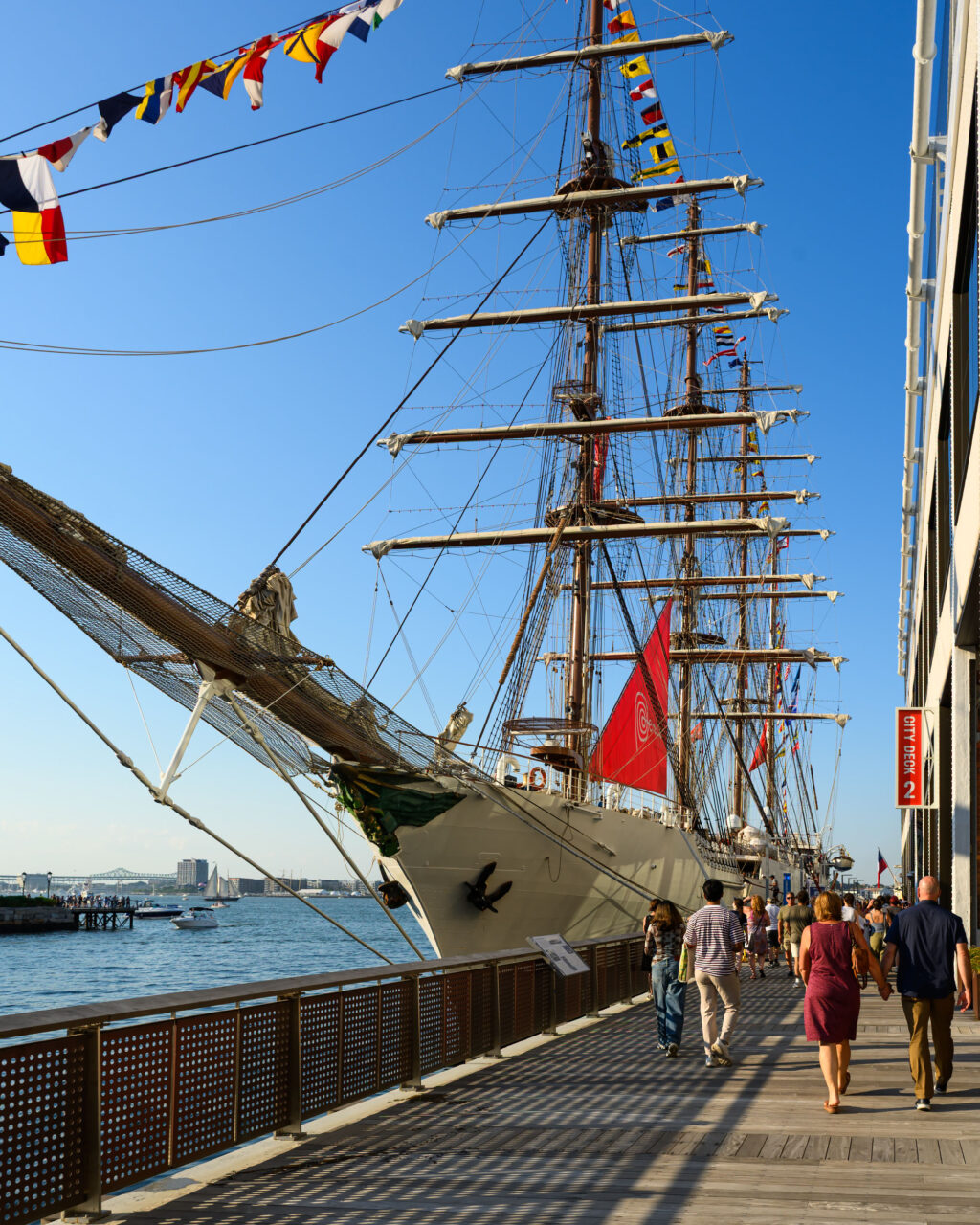 Tall ship bow rigged with signal flags at City Dock, Sail Boston 2026.